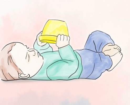 Baby liegt auf dem Rücken und hält in beiden Händen einen gelben Eimer